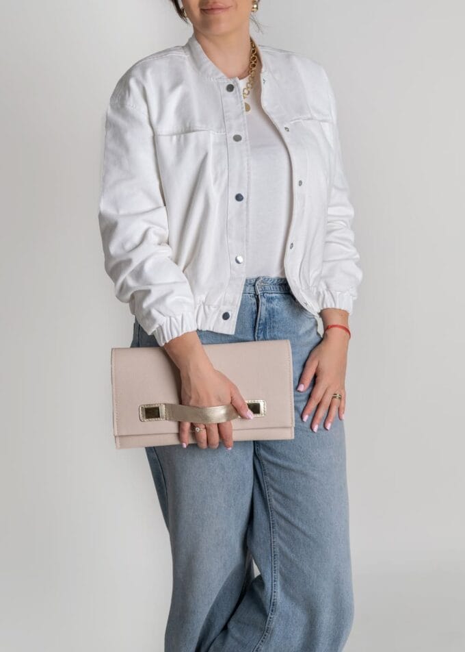 Kobieta trzymająca beżową kopertówkę Bella Beige – elegancka stylizacja z jasną kurtką i jeansami